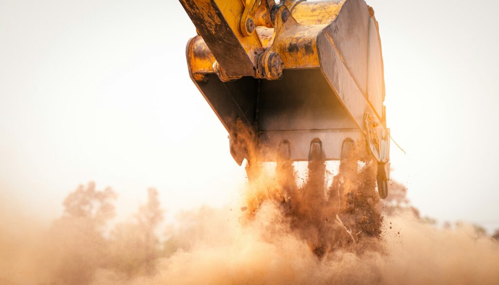 Backhoe working by digging soil at construction site bucket of crawler excavator breaking ground